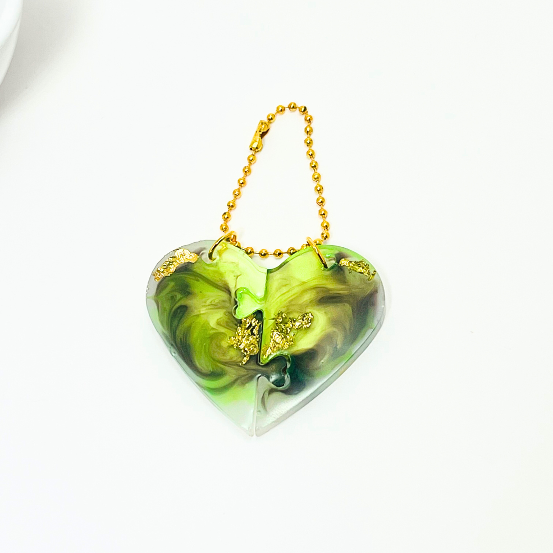 Green marble heart couple keychain with gold foil accents on a cozy neutral background – handmade personalized gift by Jucraft.